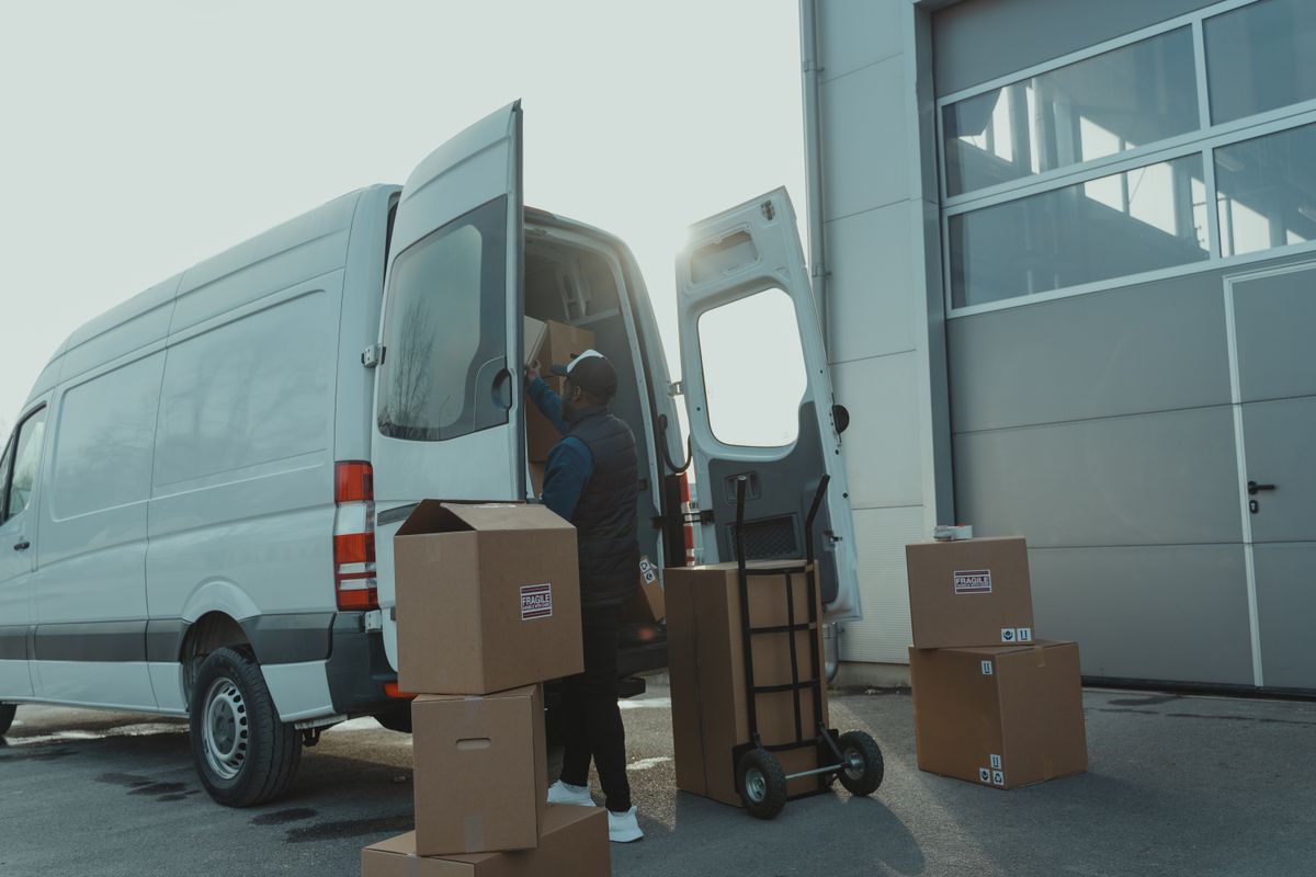 Kleintransport – Kartons werden in einen Lieferwagen geladen